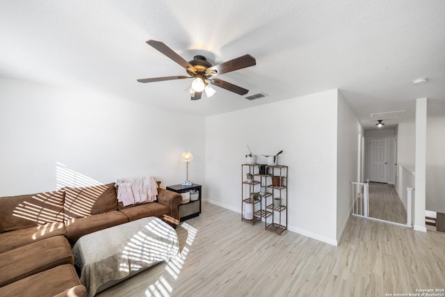 living room with ceiling fan, light hardwood / wood-style flooring, and a textured ceiling