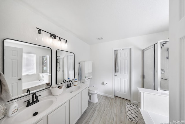 full bathroom with vanity, toilet, separate shower and tub, and hardwood / wood-style floors