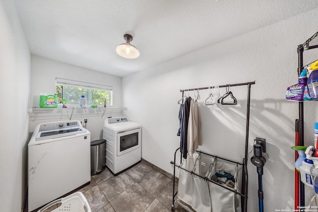 laundry area with a textured ceiling and washing machine and clothes dryer