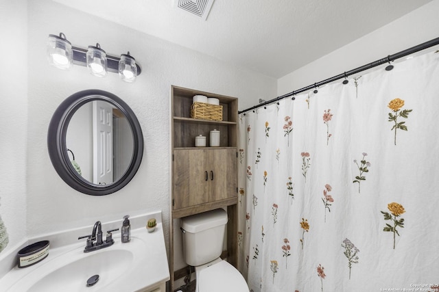 bathroom with vanity, a textured ceiling, and toilet