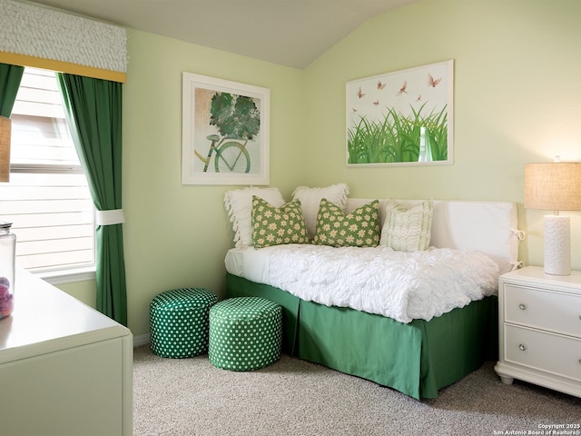 carpeted bedroom with lofted ceiling