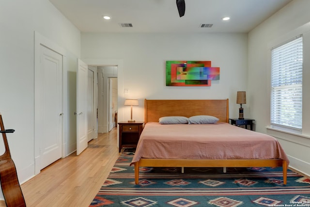 bedroom with multiple windows, ceiling fan, and light wood-type flooring