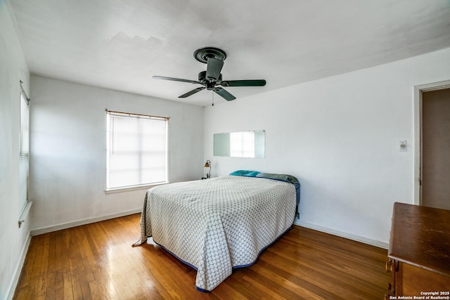 bedroom with dark wood-style floors, baseboards, and a ceiling fan