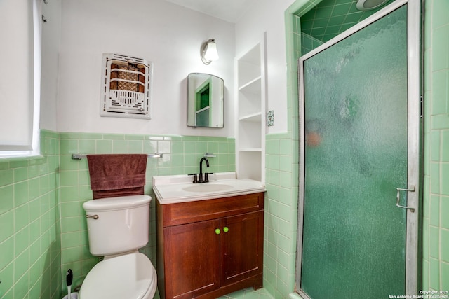 bathroom with a stall shower, vanity, toilet, and tile walls