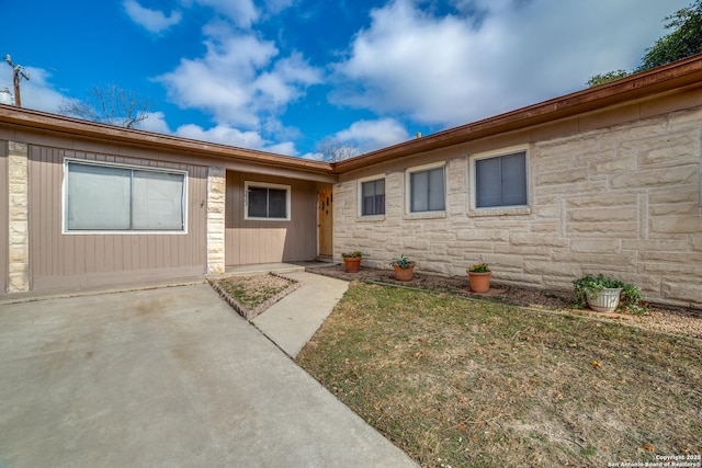 view of front of property with stone siding and a patio area