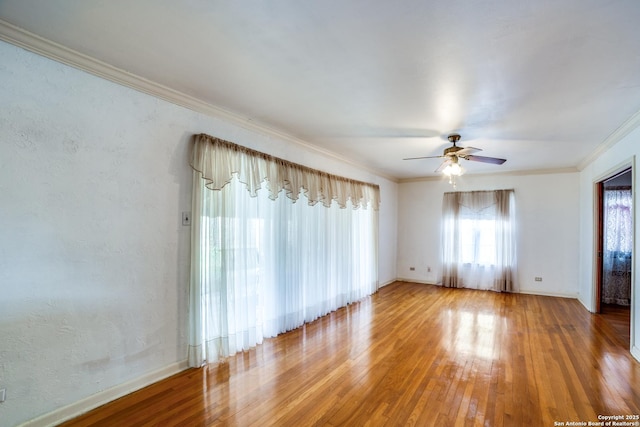 empty room with ceiling fan, ornamental molding, wood finished floors, and a textured wall