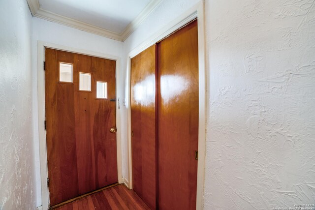 doorway to outside featuring wood finished floors, crown molding, and a textured wall