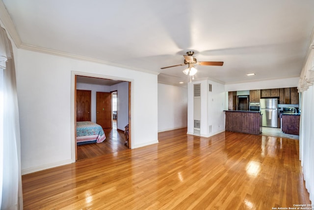 unfurnished living room featuring baseboards, light wood-type flooring, and crown molding