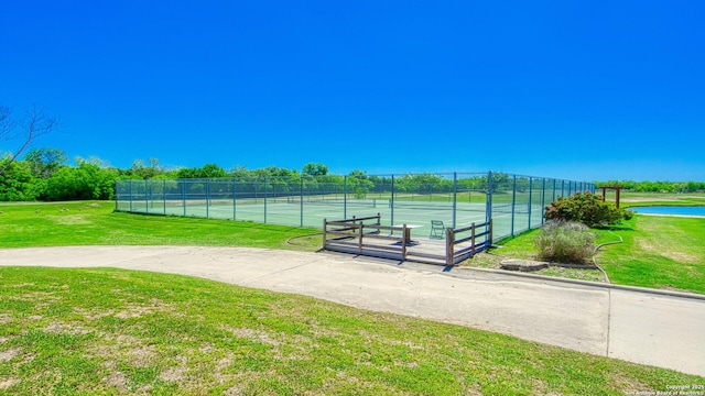 view of community with a yard and tennis court