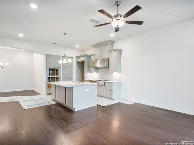 kitchen featuring a kitchen island with sink, backsplash, decorative light fixtures, and gray cabinets