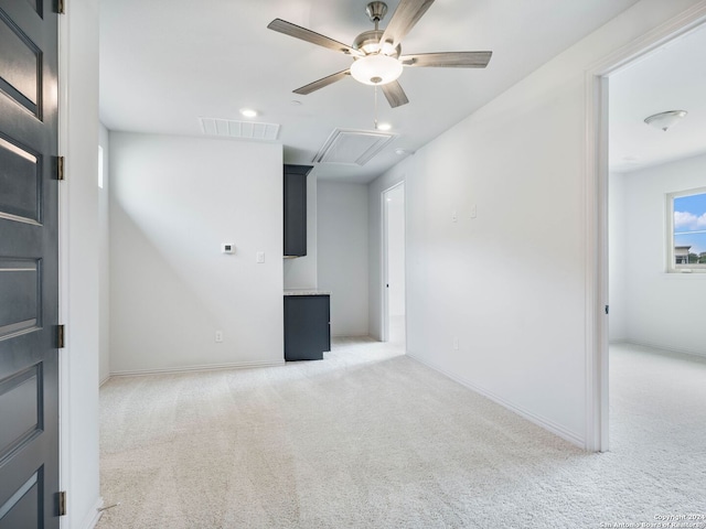 basement featuring light carpet and ceiling fan