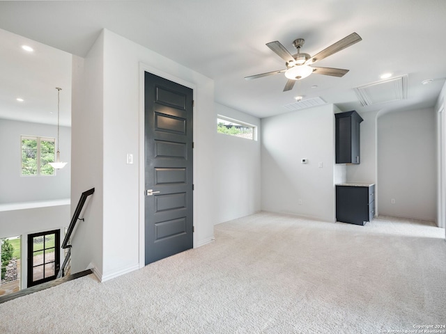 unfurnished living room featuring carpet, plenty of natural light, and ceiling fan