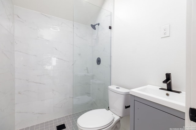 bathroom with vanity, toilet, and a tile shower