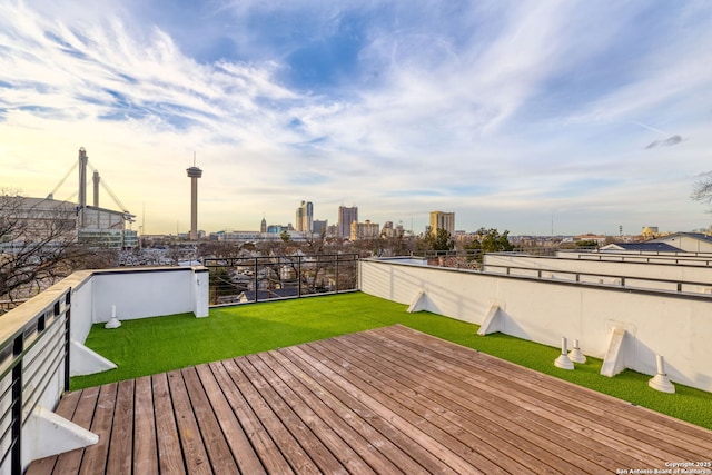 deck at dusk featuring a lawn