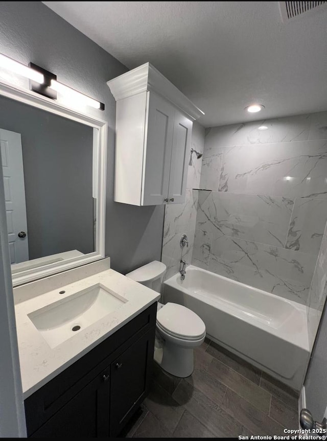 full bathroom with vanity, toilet, and tiled shower / bath