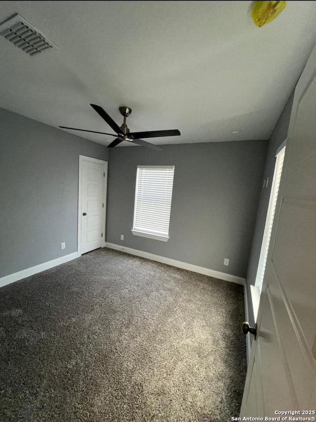 carpeted spare room featuring ceiling fan