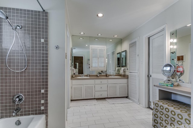 bathroom featuring vanity, tile patterned flooring, and tiled shower / bath