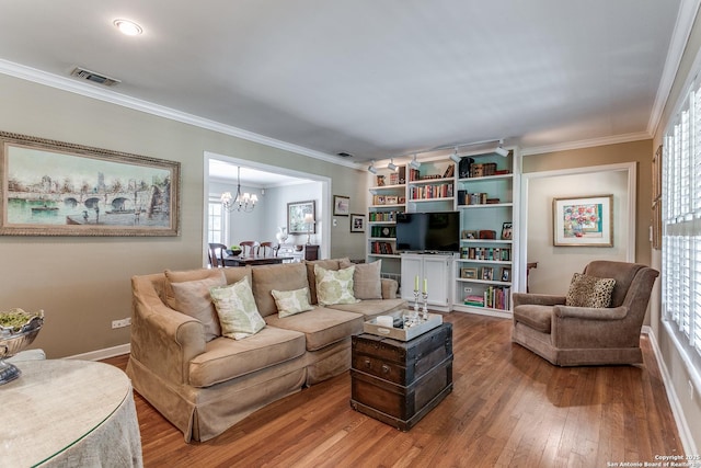 living room featuring ornamental molding, wood-type flooring, and a chandelier