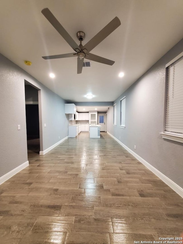 unfurnished living room with ceiling fan and hardwood / wood-style floors