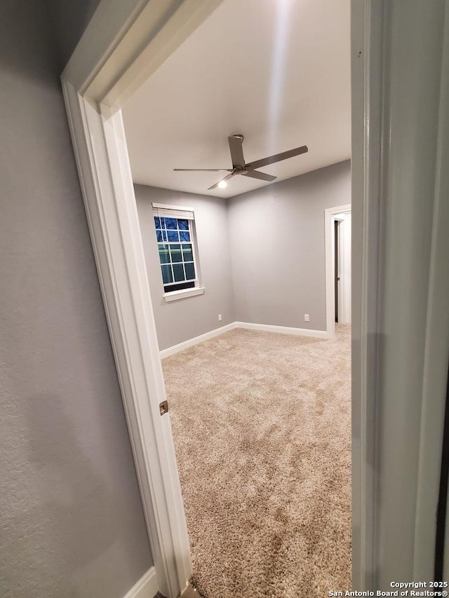 empty room with ceiling fan and carpet floors