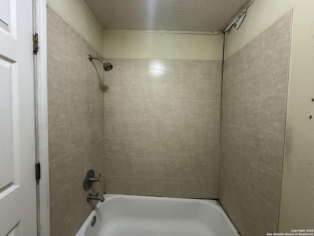 bathroom featuring tiled shower / bath and a textured ceiling