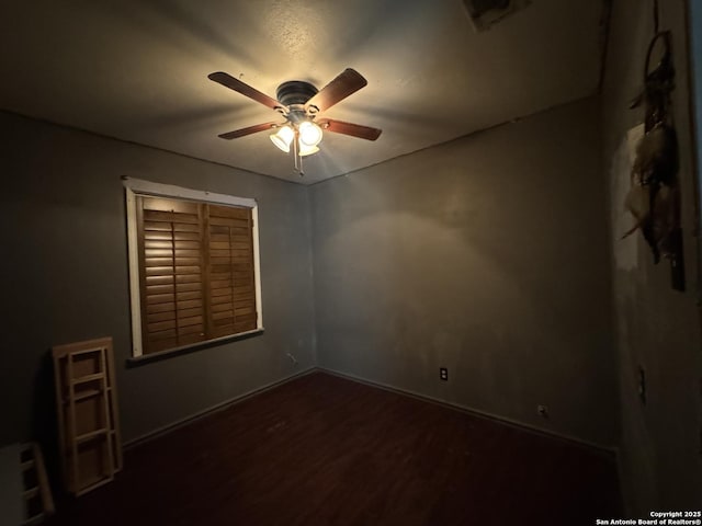 unfurnished room with dark hardwood / wood-style floors and ceiling fan