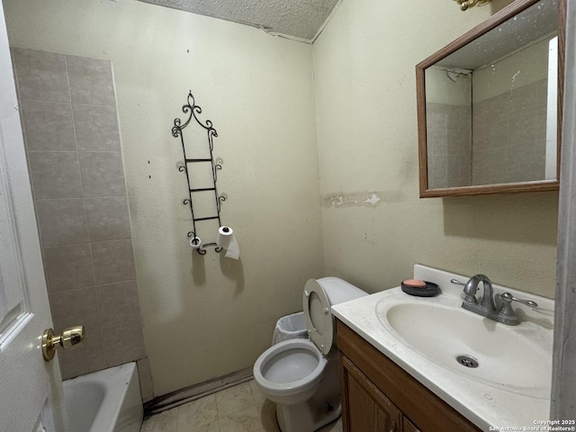 bathroom featuring vanity, a textured ceiling, and toilet