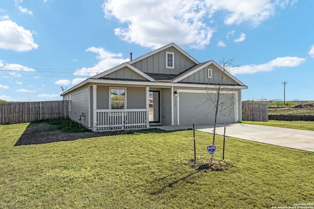 view of front of property with a garage, covered porch, and a front lawn