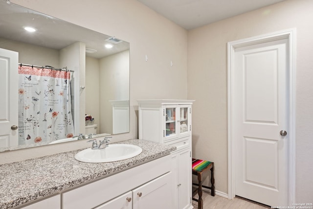 439 Agave Cir, Jourdanton, TX 78026 - bathroom featuring vanity, hardwood / wood-style floors, a shower with curtain, and toilet