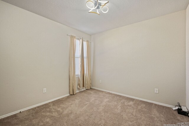 439 Agave Cir, Jourdanton, TX 78026 - spare room with light carpet and a textured ceiling