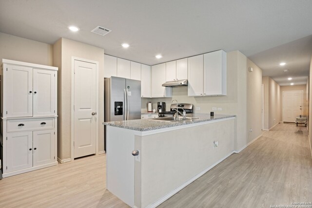 439 Agave Cir, Jourdanton, TX 78026 - kitchen featuring sink, stainless steel fridge, light stone countertops, light hardwood / wood-style floors, and white cabinets