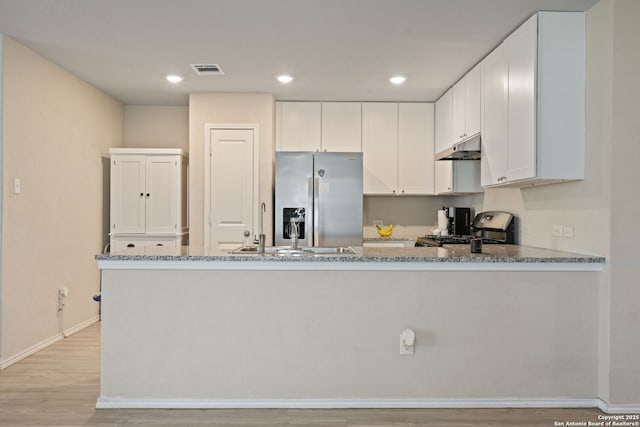 439 Agave Cir, Jourdanton, TX 78026 - kitchen featuring appliances with stainless steel finishes, white cabinetry, sink, light stone counters, and kitchen peninsula