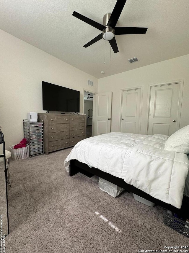 bedroom featuring ceiling fan, light carpet, and a textured ceiling