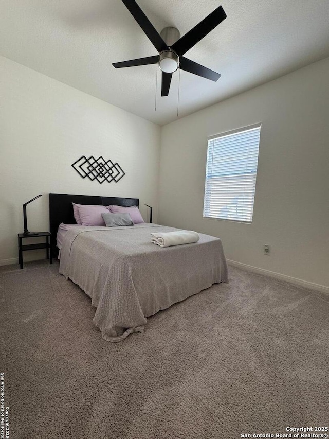 carpeted bedroom with ceiling fan and a textured ceiling