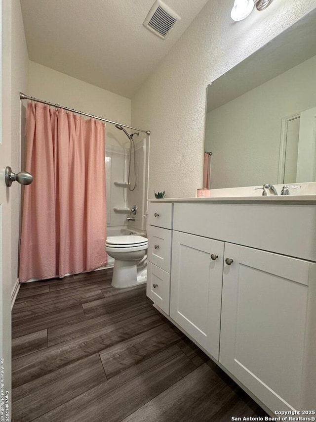 full bathroom featuring shower / tub combo with curtain, vanity, wood-type flooring, and toilet