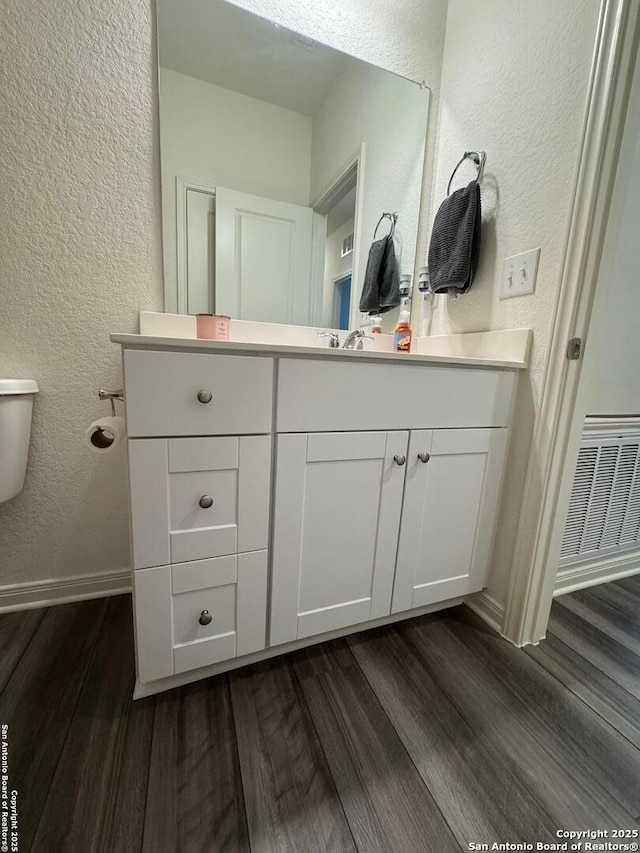 bathroom with vanity, hardwood / wood-style flooring, and toilet