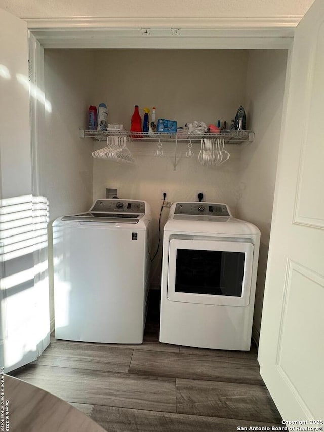 laundry room with wood-type flooring and independent washer and dryer