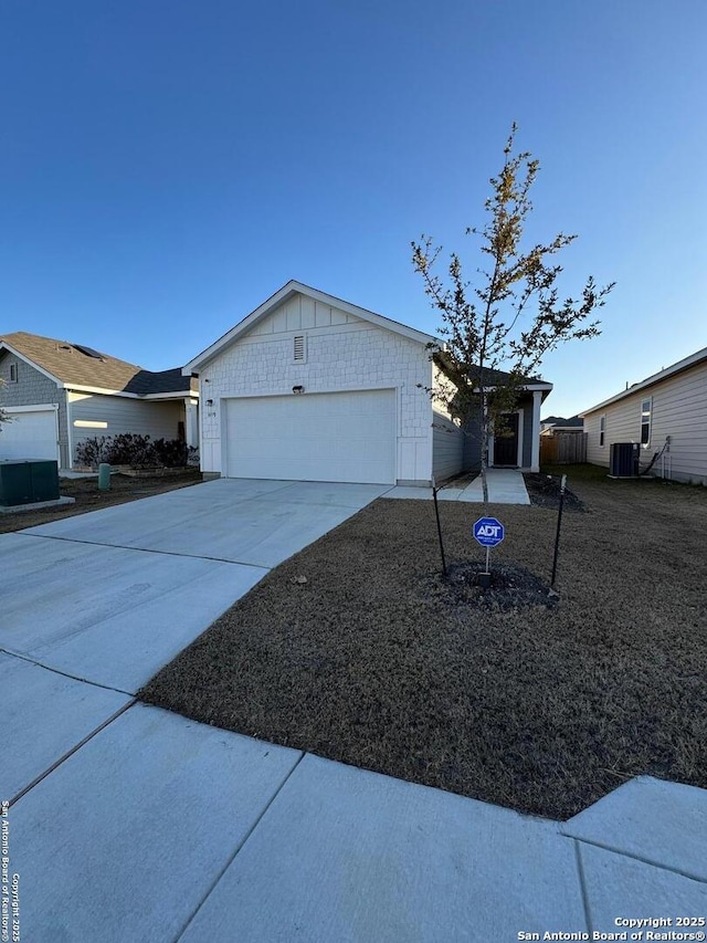 single story home featuring a garage and central AC unit