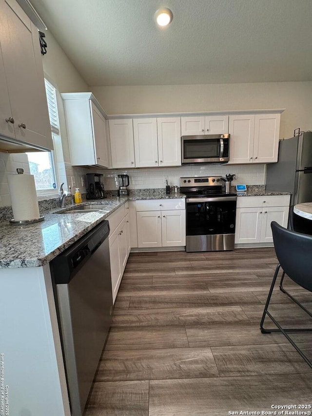 kitchen with white cabinetry, tasteful backsplash, and stainless steel appliances