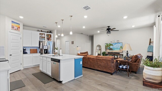 2437 Hiddenbrooke Trce, Seguin, TX 78155 - kitchen with sink, white cabinetry, hanging light fixtures, a center island with sink, and stainless steel appliances