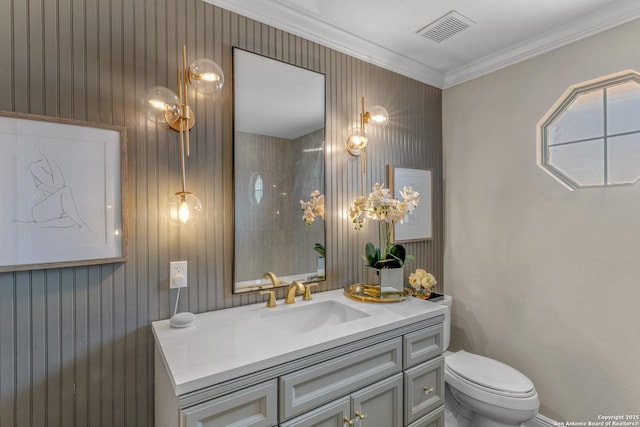 bathroom featuring vanity, crown molding, and toilet