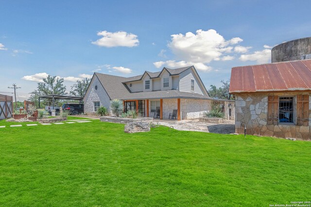 back of house featuring a carport, a patio, and a lawn