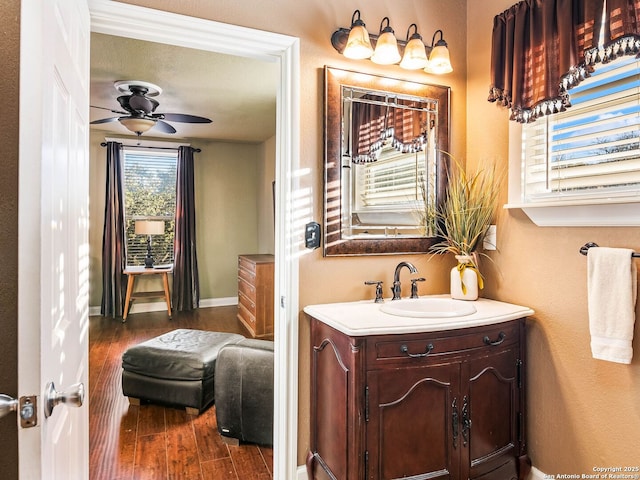 bathroom with ceiling fan, vanity, and wood-type flooring