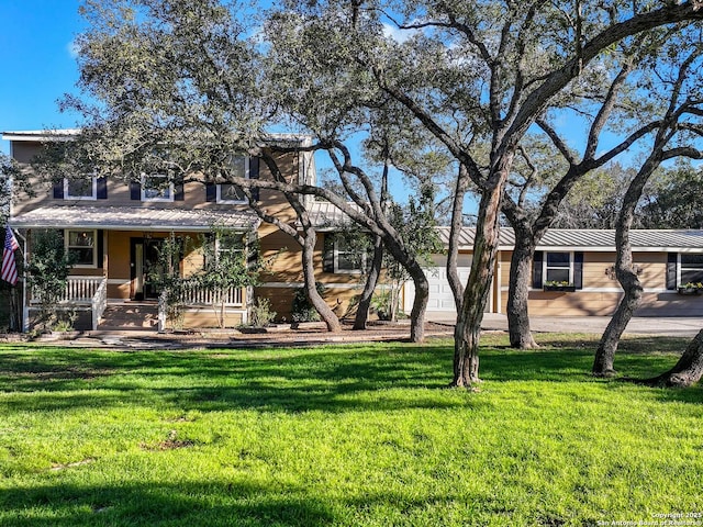 view of front of property featuring a garage, a front yard, and a porch