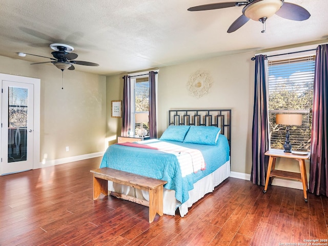 bedroom with ceiling fan, dark hardwood / wood-style floors, and a textured ceiling