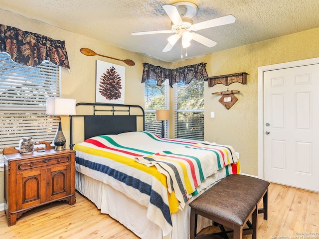 bedroom featuring ceiling fan, a textured ceiling, and light wood-type flooring