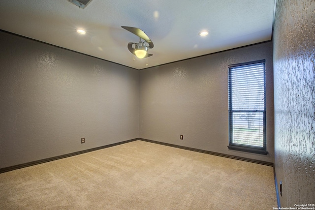 empty room with ceiling fan, a healthy amount of sunlight, and light carpet