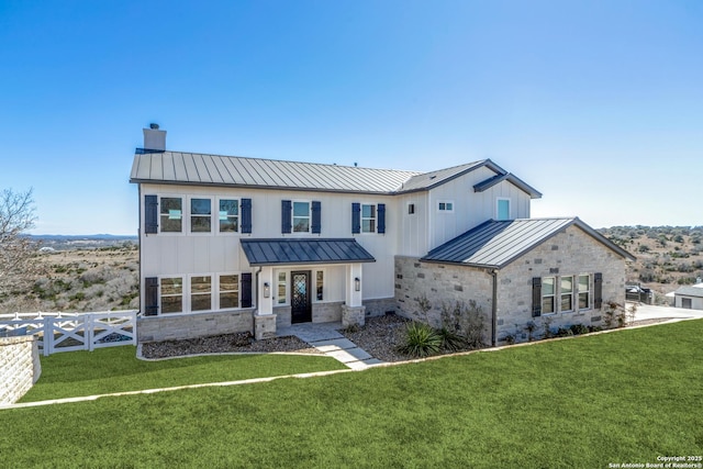 modern farmhouse style home with stone siding, a standing seam roof, and metal roof