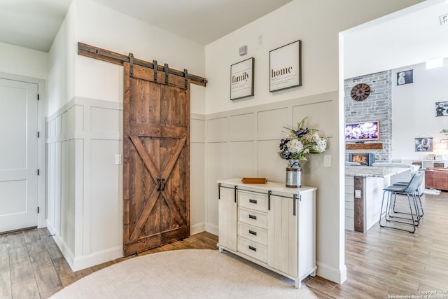 interior space featuring a wainscoted wall, a decorative wall, and wood finished floors