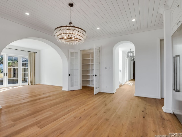 unfurnished dining area featuring ornamental molding, wooden ceiling, and a notable chandelier